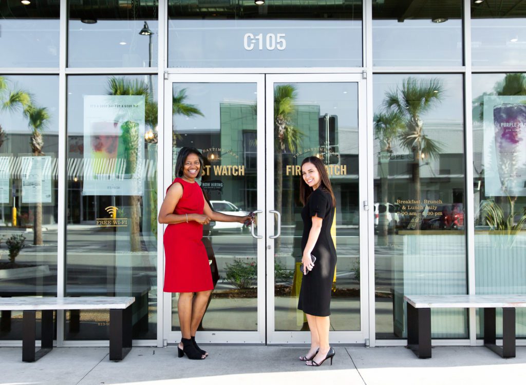 Two entrepreneurs in Jacksonville turned to smile before going through glass doors.