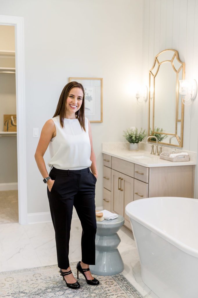 Lady in work outfit in luxury home bathroom.