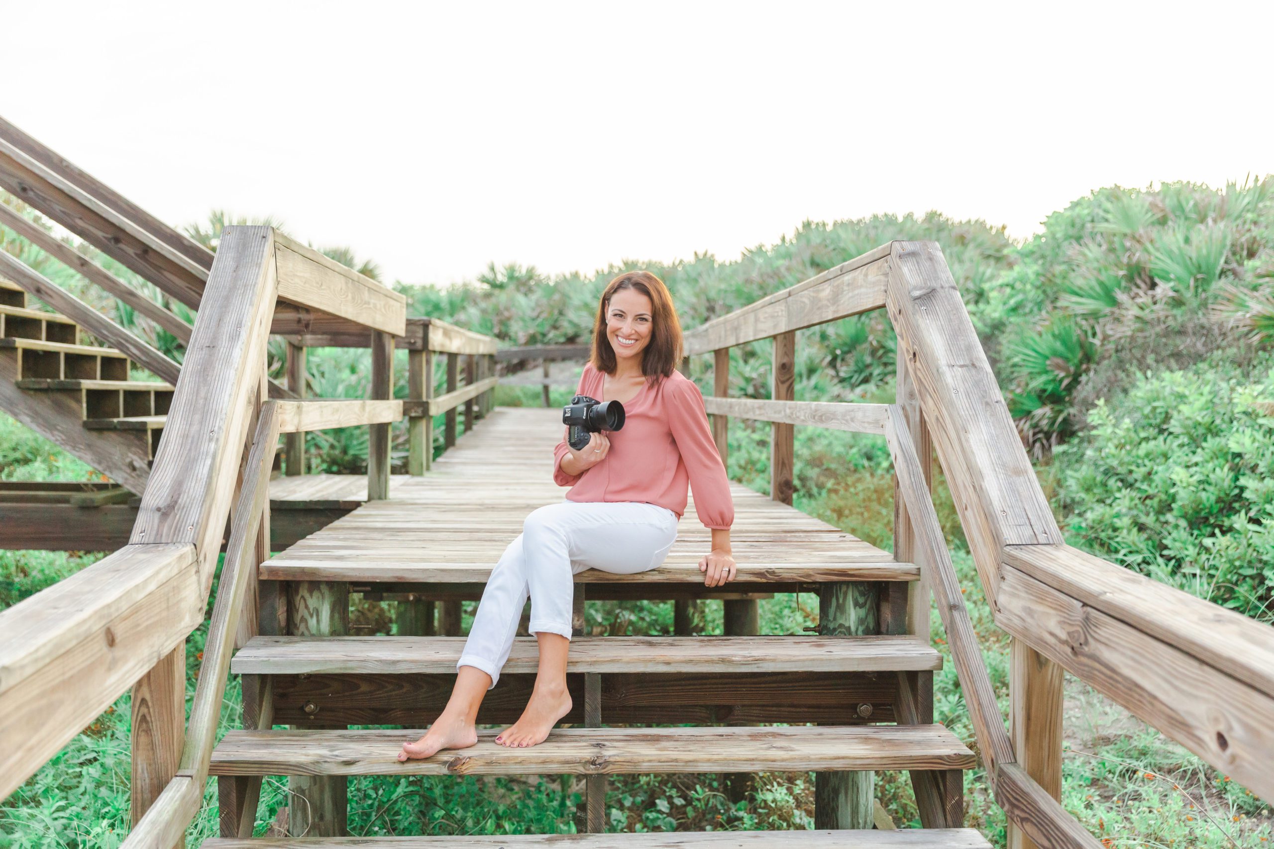 Nocatee Photographer sitting on stairs at guana beach for branding shoot.