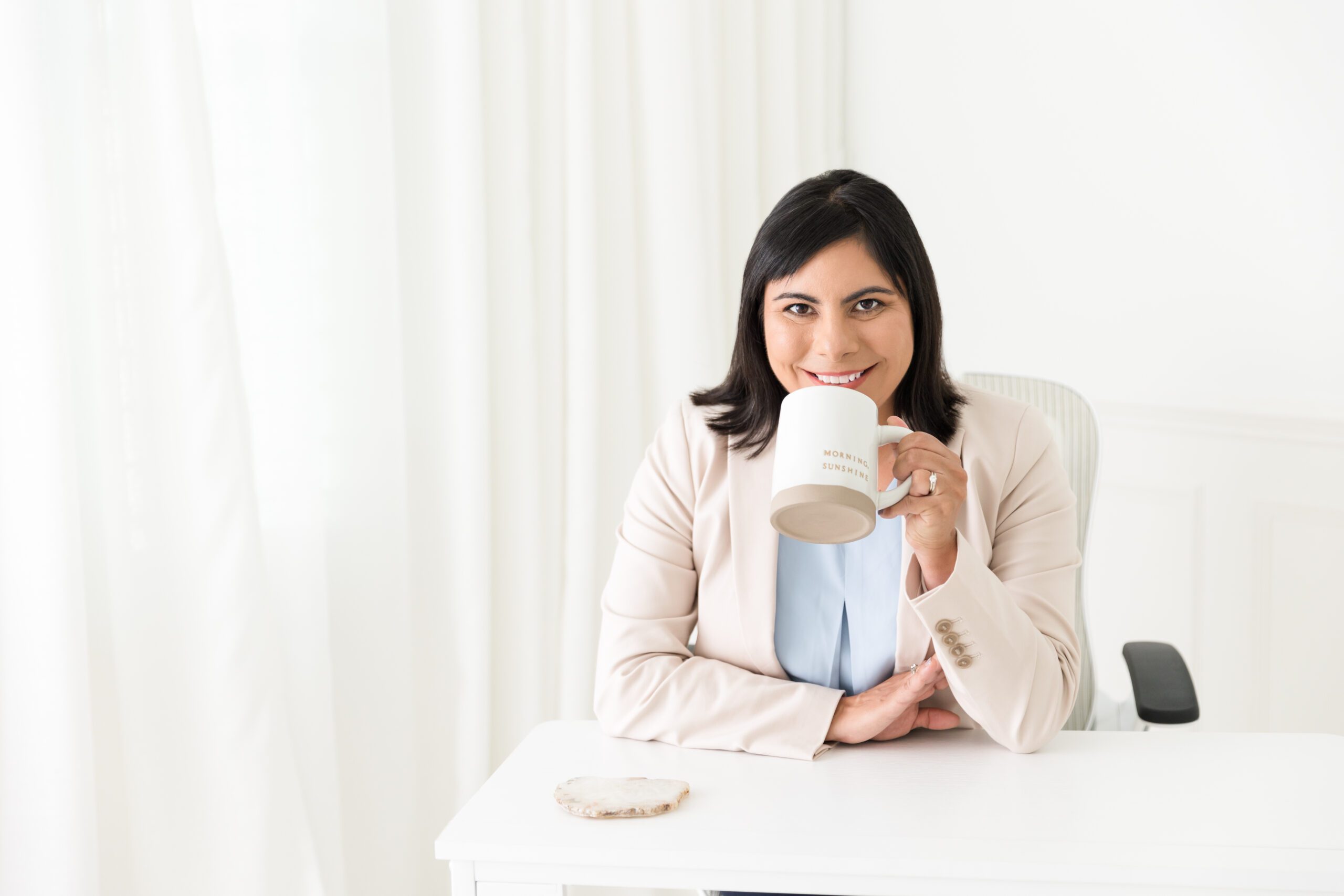 non profit writer holding cup sitting at desk